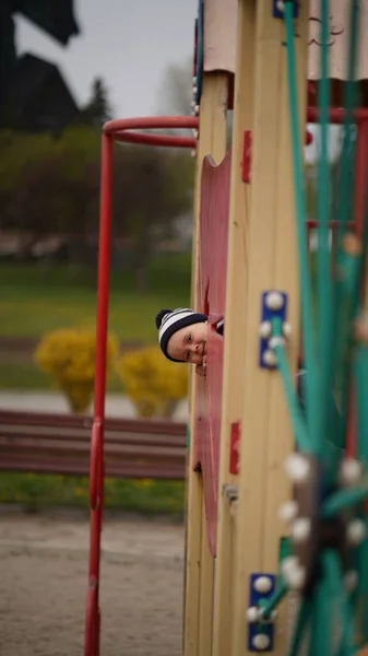 Kleiner Süßer Junge Mit Hut Steckt Seinen Kopf Kinderspielplatz — Stockfoto