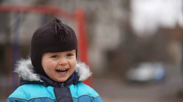 Portret Małego Śmiejącego Się Chłopca Niebieskiej Kurtce Brązowej Czapeczce Parku — Zdjęcie stockowe