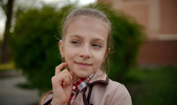 在春天的公园里 一个有着一头长发的漂亮微笑的女孩的画像用手指触摸着她的脸 — 图库照片