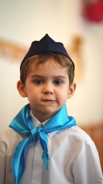 幼稚园里穿着白衬衫和蓝领巾的可爱滑稽男孩的画像 — 图库照片