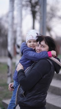Baharda parkta beyaz şapkalı şirin bir kızı olan güzel bir anne. Mutlu aile ve bahar kavramı