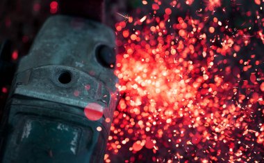 Disk öğütücüsüyle metal kesmek. Bulanık kıvılcımlar ve eski ekipmanlar