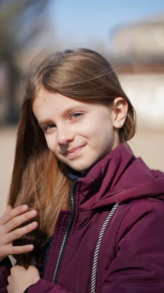 春に公園で長い茶色の髪をしたかなり笑顔の女の子の肖像画 — ストック写真