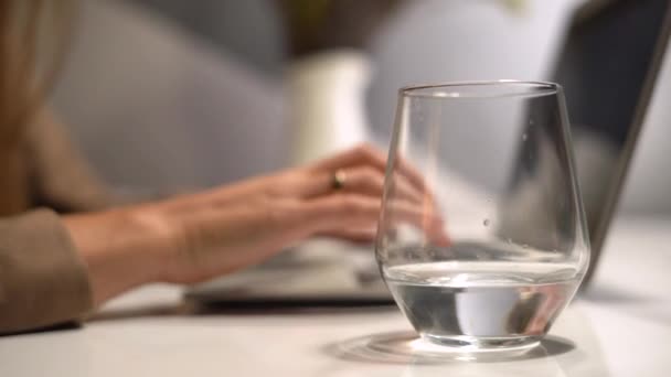 Forretningskvinde drikker vand ved sit skrivebord på sit kontor – Stock-video