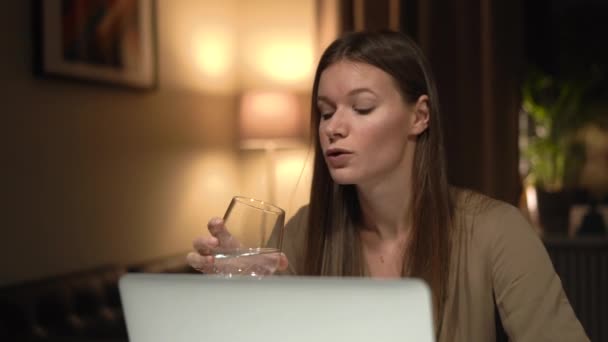 Ofiste dizüstü bilgisayarla çalışan bir kadın. Temiz su iç.. — Stok video