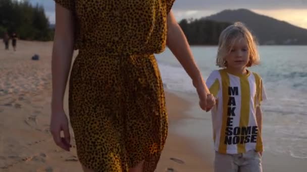 Mamá e hijo caminan por la playa. Primer plano — Vídeo de stock