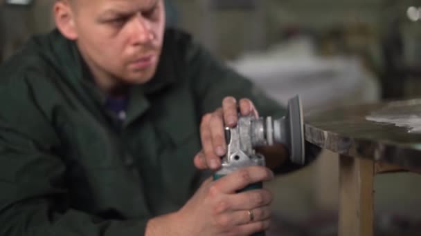 Arbeiter in grünem Sakko polieren in einer Fabrik einen Marmortisch. Superzeitlupe — Stockvideo