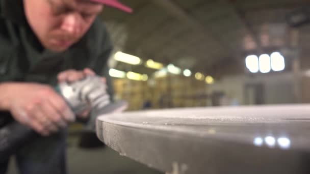 Trabajador puliendo una mesa de mármol oscuro en una fábrica. Ángulo ancho. El sujeto se desenfoca para concentrarse. Super cámara lenta — Vídeo de stock