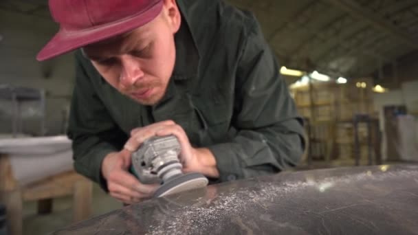 Portrait of a serious worker polishing a dark marble table in a factory. Wide angle. Super Slow Motion — Stock Video