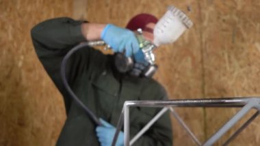 İşçi Metal Ürünleri Havasız Spreyle Boyuyor. Kamera odaklanmak için çözünürlükten hareket eder. Yavaş çekim