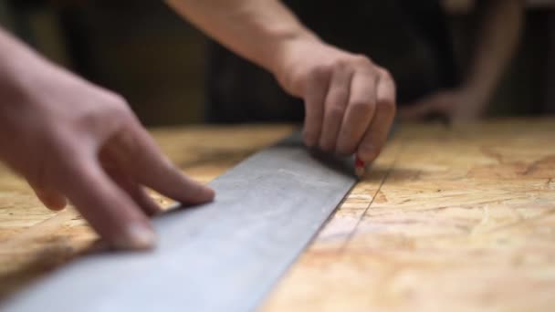 Manos del hombre usando una regla para hacer mediciones en un pedazo de madera. Lento. — Vídeos de Stock