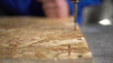 İşçi adam vidayı tornavidayla sıkılaştırıyor. Kamera odaklanmak için çözünürlükten hareket eder. Yavaş çekim