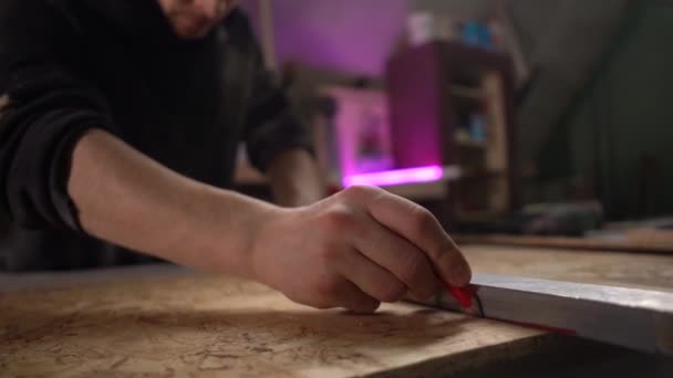 Manos del hombre usando una regla para hacer mediciones en un pedazo de madera. Ángulo ancho — Vídeo de stock