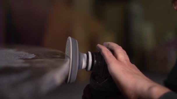 Hands of a worker who polishes a dark marble table with with a grinder. Super Slow Motion. The camera moves with the subject — Stock Video