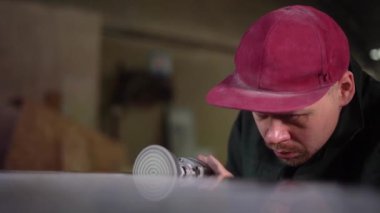  Fabrikadaki koyu mermer masayı dikkatlice cilalayan ciddi bir işçinin portresi. Süper Yavaş Hareket