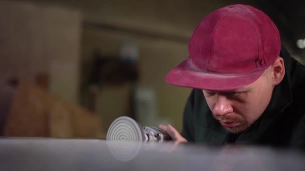 Portrait of a serious worker who carefully polishes a dark marble table at the factory. Super Slow Motion — Stock Video