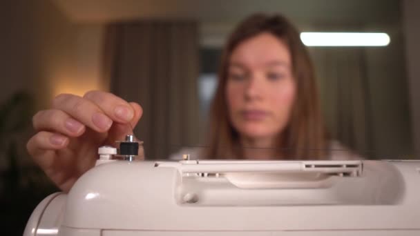 집에서 재봉틀에 비닐봉지를 감고 있는 여자 — 비디오