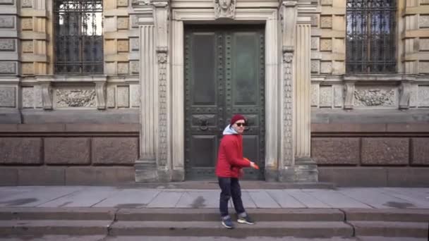 Muž hodí frisbee na pozadí historické budovy v Petrohradě. Zpomal. Záběr steadicamu — Stock video