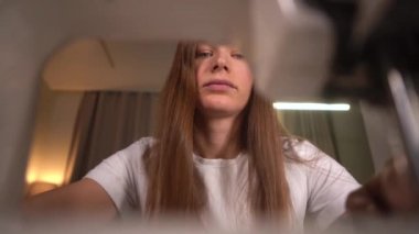  Kadın dikiş makinesine dikiş dikiyor. Kadın evde çalışıyor..