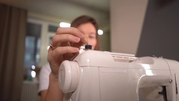 Jeune femme enroulant une canette sur une machine à coudre — Video