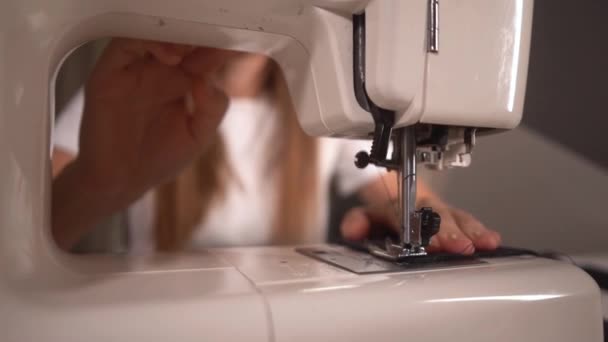 Mulher costura uma máscara protetora preta em uma máquina de costura no apartamento — Vídeo de Stock