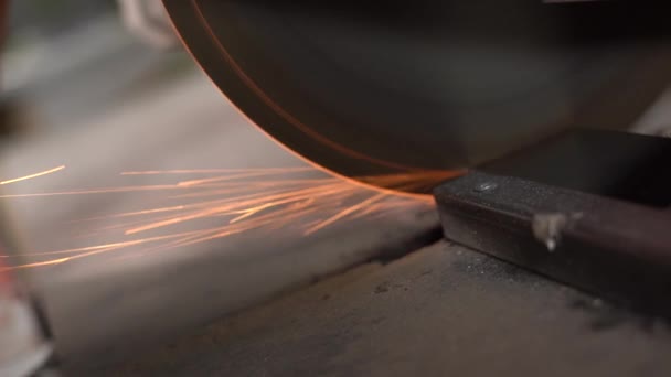 Lavoratori professionisti che tagliano metallo con sega circolare in fabbrica. Rallentatore. La telecamera si muove con la sega — Video Stock