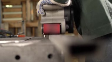  Çilingir, fabrikada öğütücü kullanarak metal parçaları öğütüyor. Arka plan