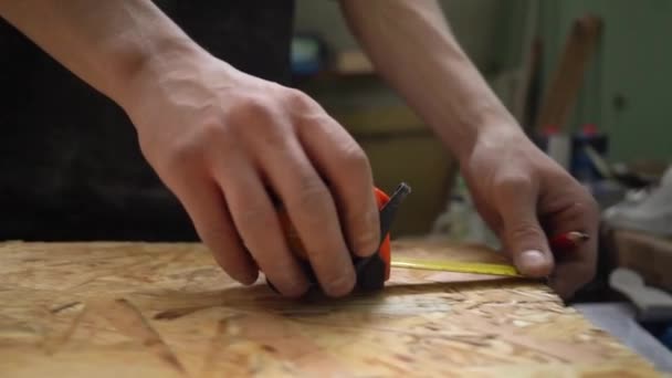 Карпентер вимірює дерев'яну дошку. ОББ. — стокове відео