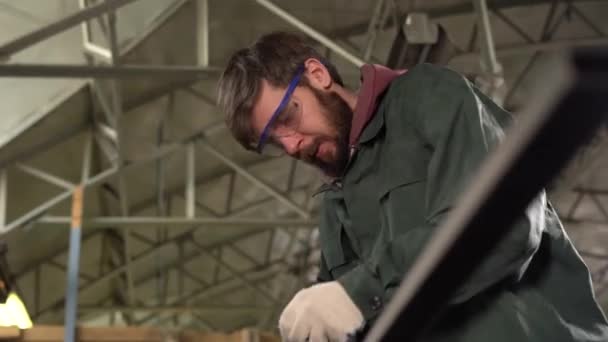 Il lavoratore macina il dettaglio metallico utilizzando la smerigliatrice in fabbrica . — Video Stock