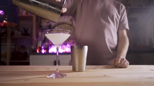 Lento movimento lungo colpo della mano baristi versando un cocktail da uno shaker in un bicchiere . — Video Stock