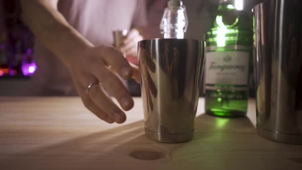 Ein Barmann nimmt einen Shaker und gießt Jiggersirup in Zeitlupe hinein. Die Kamera folgt dem Objekt. — Stockvideo