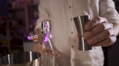 Barmen şeker şurubunu bir zencefilden karıştırıcıya döküyor. Yavaş çekim.