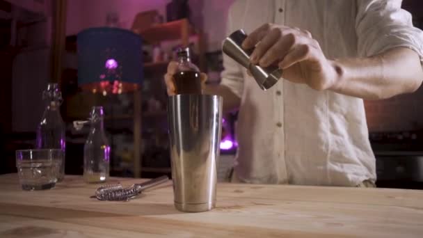 Der Barkeeper gießt Whiskey aus einer Jigger in einen Shaker. Zeitlupe. — Stockvideo