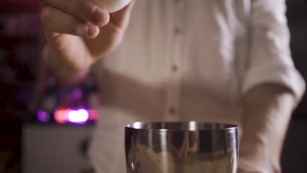 Bartenders hands breaks the egg, protein flows out of the egg into the shaker — Stock Video