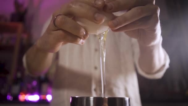 Zamknij barmanów ręce rozbija jajko, białko wypływa z jajka do shakera — Wideo stockowe