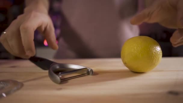 Chiudi Il barista prende una buccia per tagliare la scorza da un limone. Lento movimento. la telecamera segue l'oggetto — Video Stock