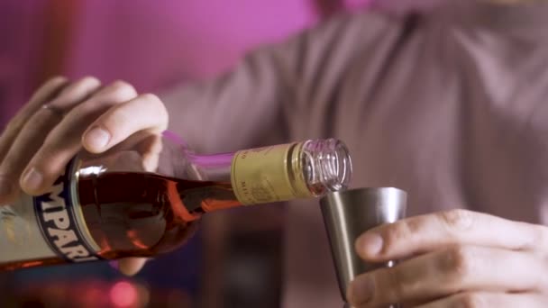 Feche os bartenders mãos derrama licor campari de uma garrafa em um quebra-cabeças. Movimento lento. — Vídeo de Stock