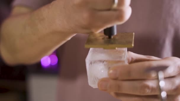 Le barman met un timbre sur un glaçon. Ferme là. Mouvement lent