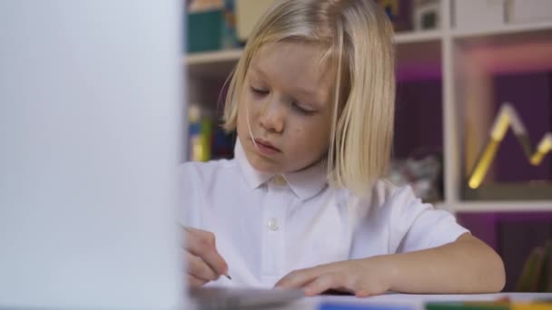 Εξ αποστάσεως εκπαίδευση λόγω καραντίνας, online εκπαίδευση. Ένα μικρό αγόρι που μαθαίνει στον υπολογιστή στο σπίτι — Αρχείο Βίντεο