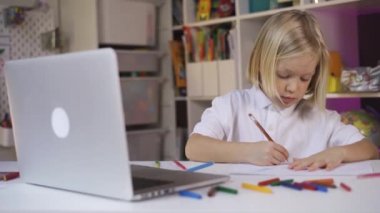 Uzaktan öğrenme çevrimiçi eğitim. Küçük bir çocuk evde öğretmeniyle çevrimiçi çalışıyor.. 