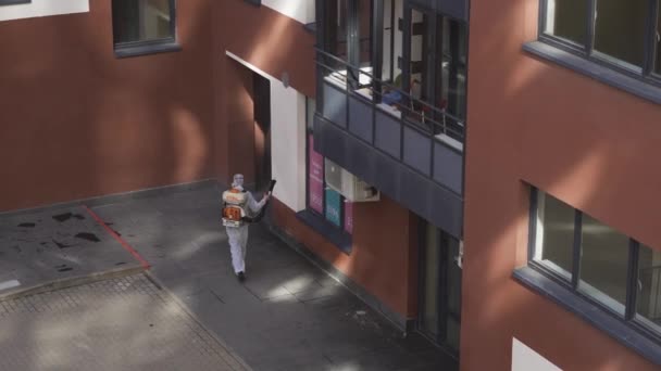 Людина Чоловіки Білому Захисному Костюмі Розпилюють Дезинфекційну Рідину Стінах Будинку — стокове відео