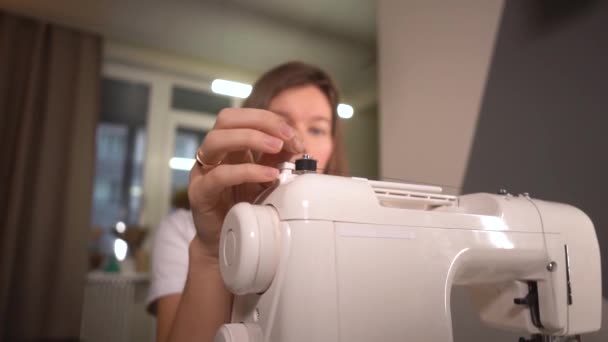 Mulher enrolando uma bobina em uma máquina de costura em casa — Vídeo de Stock