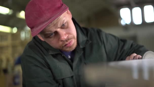 Portrait d'un ouvrier sérieux polissant une table en marbre foncé. Super ralenti — Video