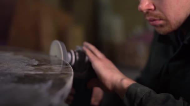 Hände eines Arbeiters, der mit einem Schleifer einen dunklen Marmortisch poliert. Super-Zeitlupe. Kamera rückt vor — Stockvideo