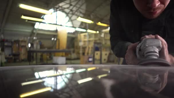 緑のジャケットの労働者は工場で大理石のテーブルを研磨します。広角 — ストック動画
