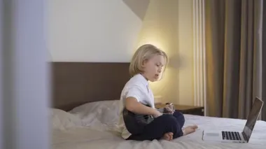 Uzaktan öğrenme çevrimiçi eğitim. Evde dizüstü bilgisayarla gitar çalmayı öğrenen tatlı bir çocuk. Düşük ihtimal