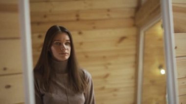 Güzel genç bayan aynaya bakıyor ve kendine hayran.