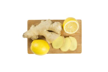 Çiğ zencefil kökü ve tahta kesme tahtasındaki dilimlerle taze limon, beyaz, stüdyo çekimi, düz görüş..