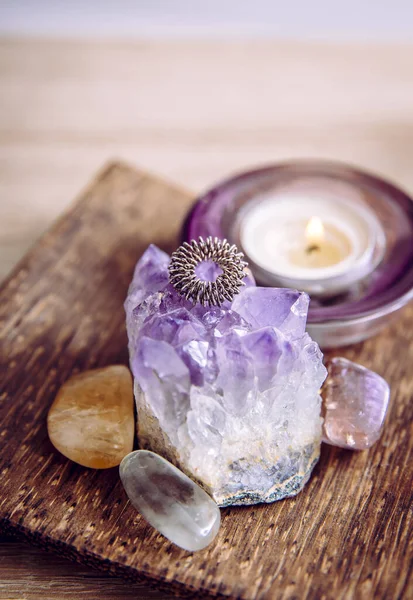 Acupressure massage ring on amethyst crystal cluster. Acupressure is an alternative medicine technique with physical pressure is applied to acupuncture points with the aim of clearing blockages.