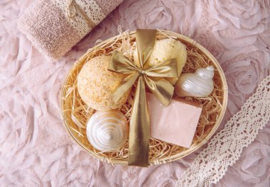 Doğal bambu malzeme sepeti. Paramparça ahşap mükemmeliyetçilikle dolu. Çeşitli spa banyo ürünleri, pembe sabun çubuğu, banyo bombası, klasik açık pembe arka planda doğal sünger. Güzellik hediyesi.